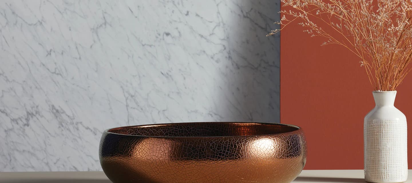 A sculptural bronze basin against marble and terracotta